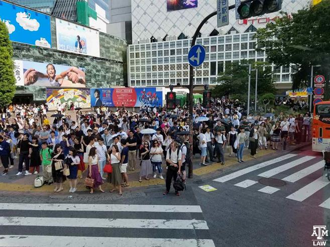 People waiting near the crosswalk at the famous Shibuya Crossing