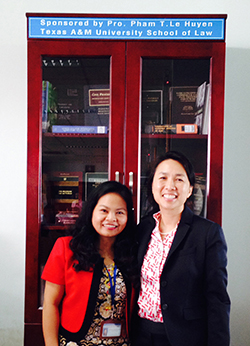 Texas A&M Law Professor Huyen Pham with the bookcase donated in her honor